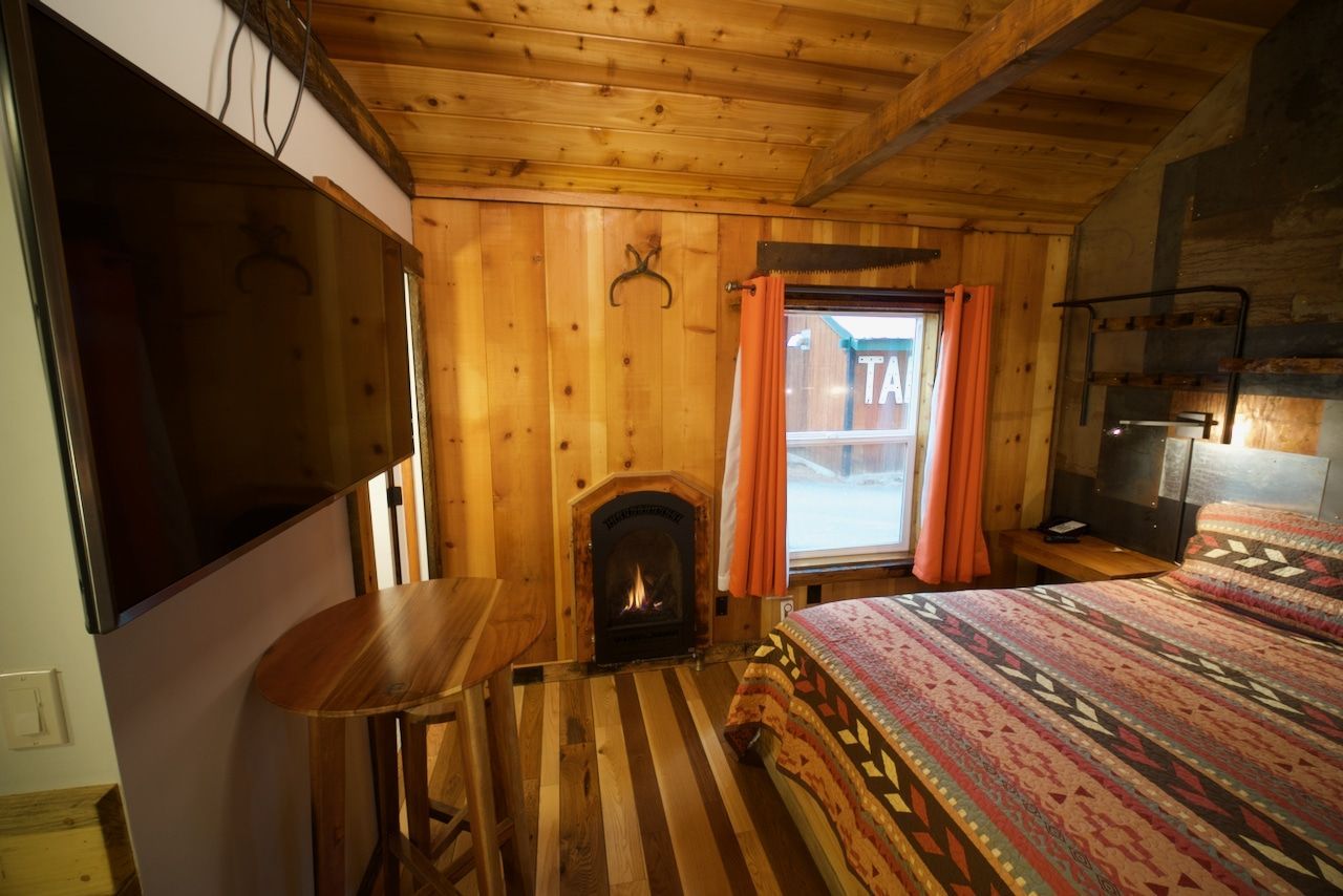 A bedroom with a bed , television and fireplace.