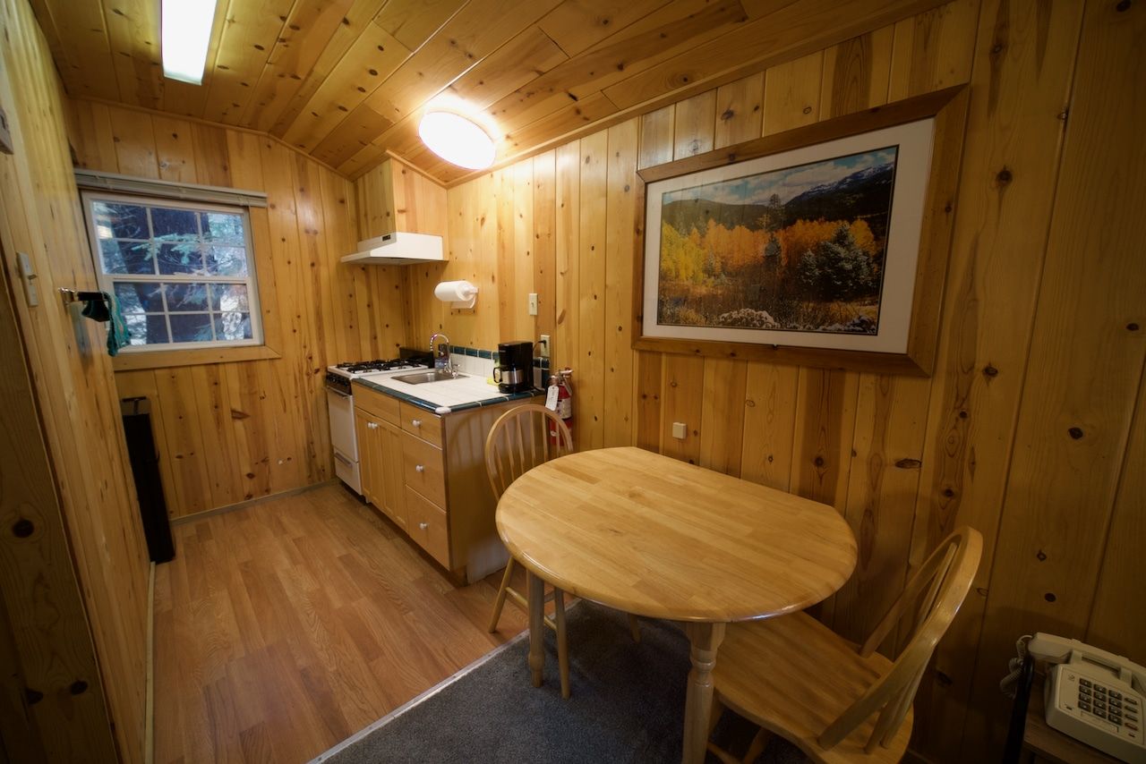 A kitchen with a table and chairs and a picture on the wall.