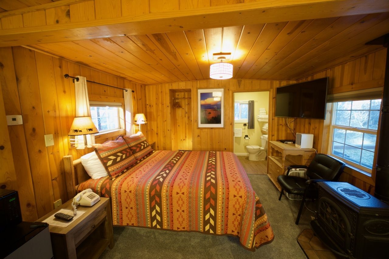 A hotel room with a king size bed and a television.