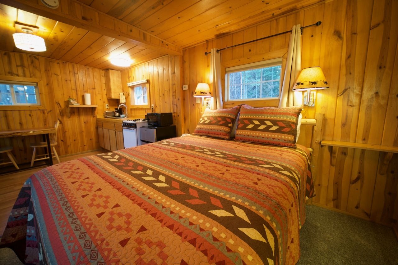 A bedroom in a cabin with a bed and a window.