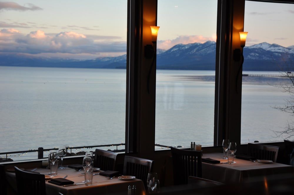 A restaurant with a view of a lake and mountains