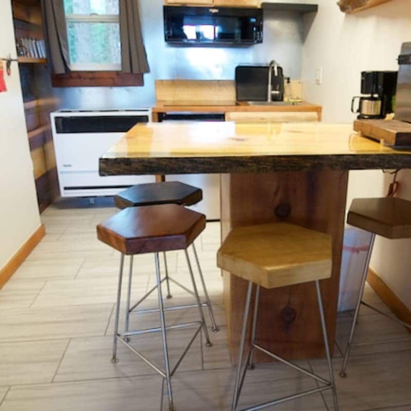 A kitchen with a table and stools in it