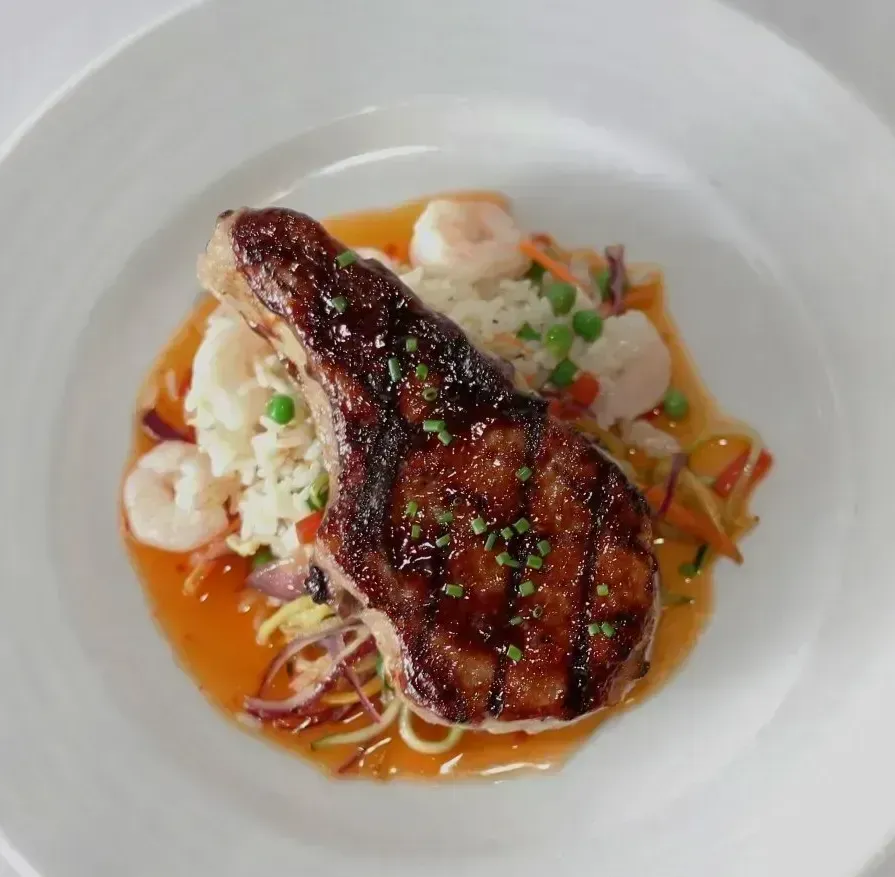 A white plate topped with a steak and shrimp