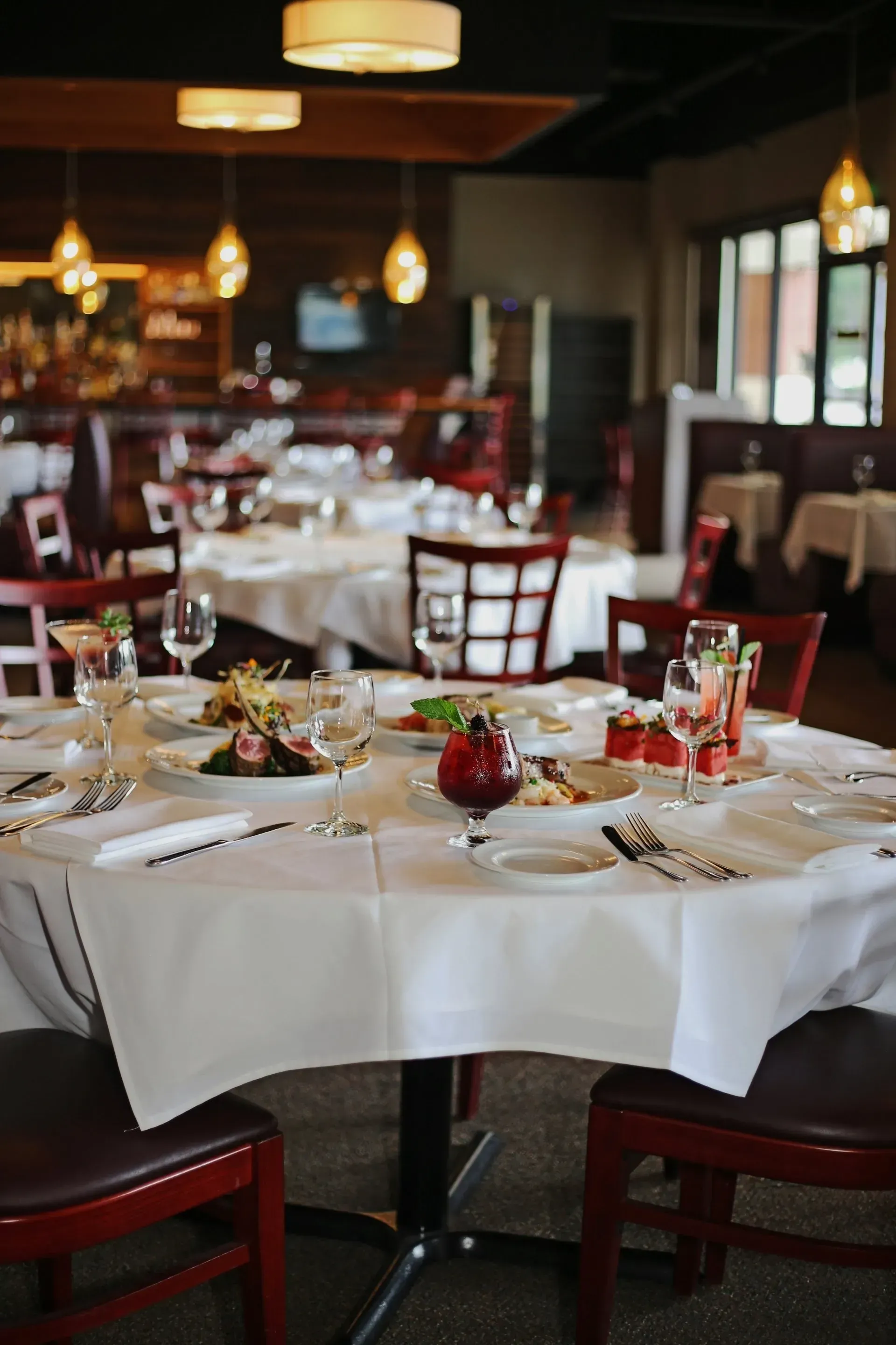 A restaurant filled with tables and chairs and plates of food.