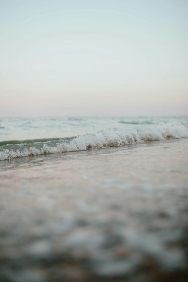 A close up of waves crashing on a beach.