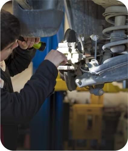 Mechanic inspecting car brakes with a flashlight in a repair shop | Allegiance Automotive