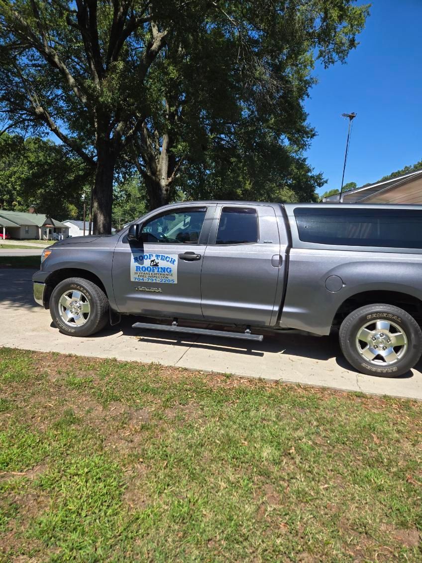 An aerial view of a red roof with workers on it.