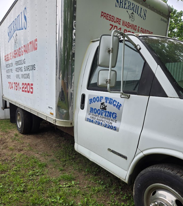 A roof tech truck is parked next to another truck