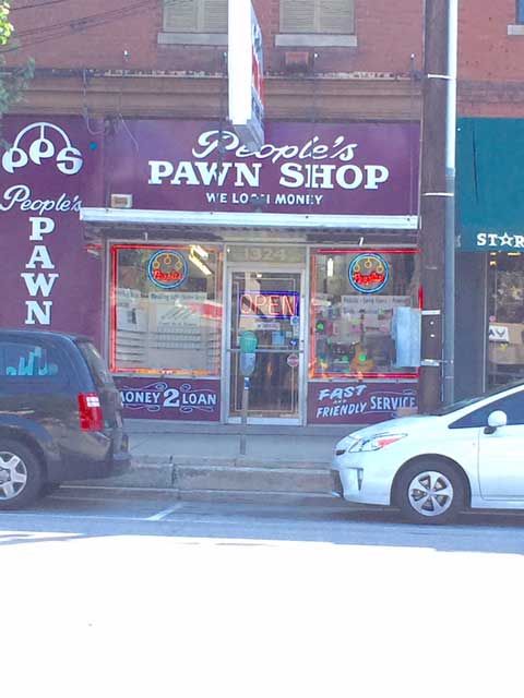 A pawn shop with cars parked in front of it