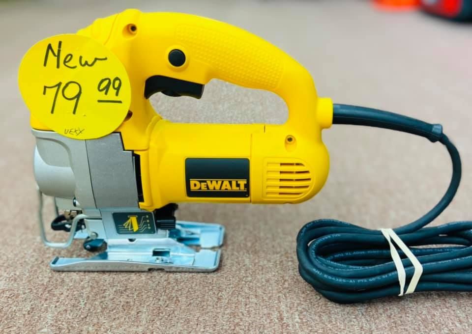 A yellow dewalt jigsaw is sitting on a carpet