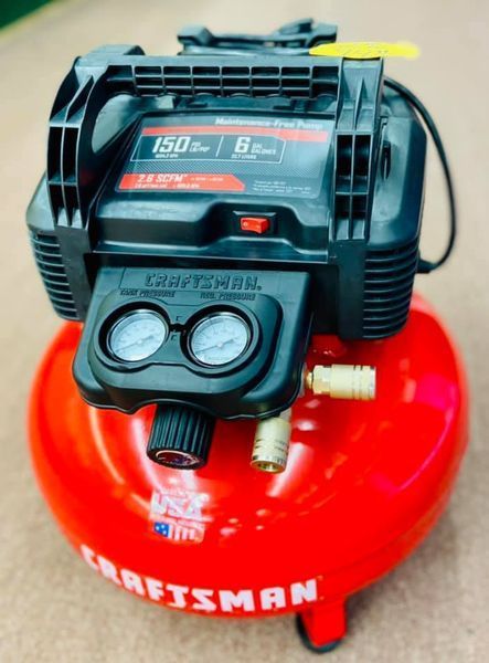 A craftsman air compressor is sitting on a carpet