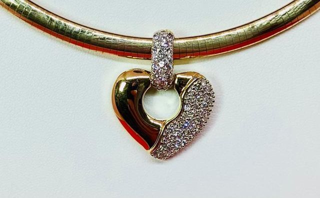 A gold necklace with a heart shaped pendant