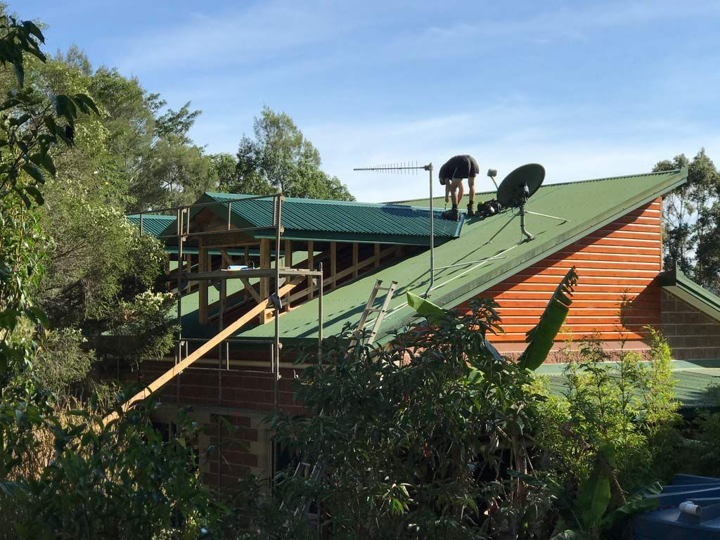 A Man is Working on the Roof of a House — Sven Margraf Constructions Pty Ltd In Atherton QLD