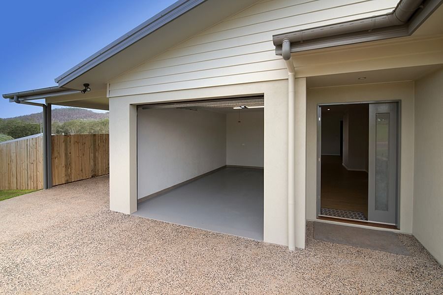 An Empty Garage With The Door Open And A Fence In The Background — Sven Margraf Constructions Pty Ltd In Atherton QLD