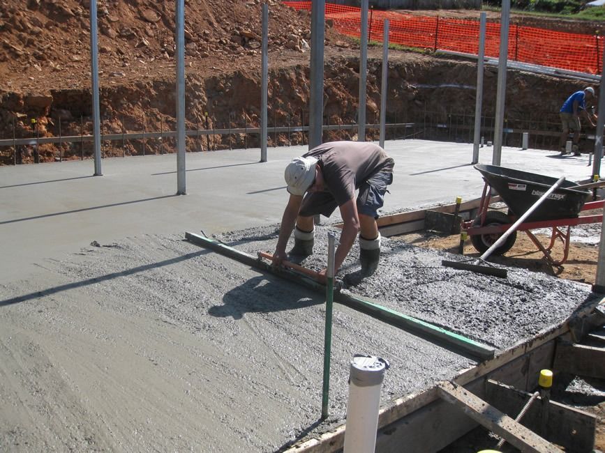 A Man Is Leveling A Concrete Floor With A Ruler — Sven Margraf Constructions Pty Ltd In Atherton QLD