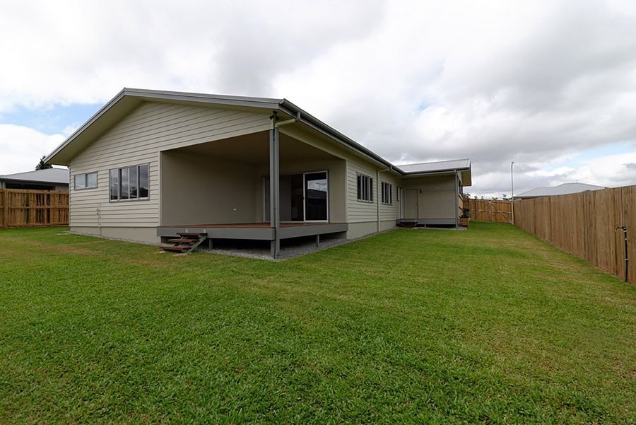 The Backyard Of A House With A Large Lawn And A Wooden Fence — Sven Margraf Constructions Pty Ltd In Atherton QLD