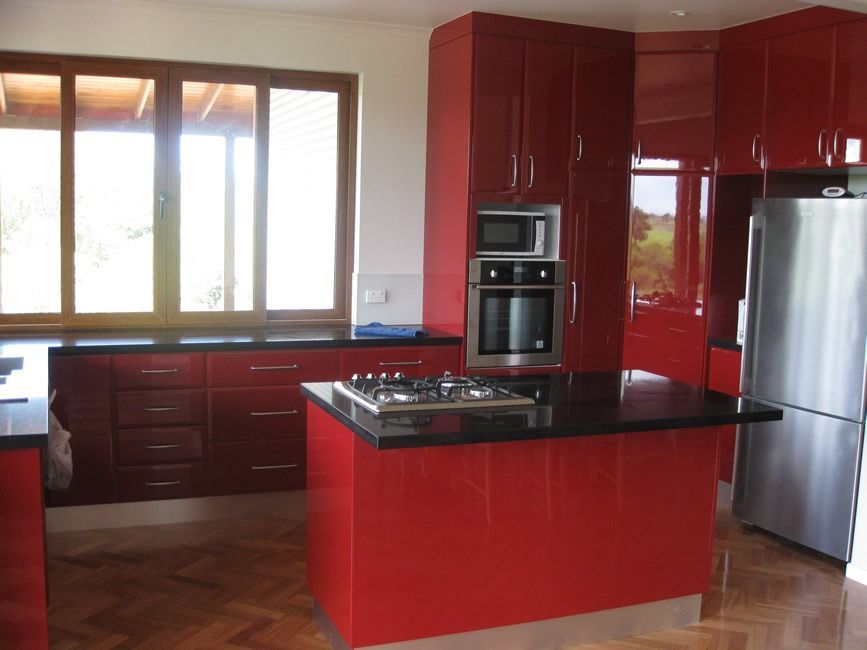 A Kitchen With Red Cabinets And A Stainless Steel Refrigerator — Sven Margraf Constructions Pty Ltd In Atherton QLD