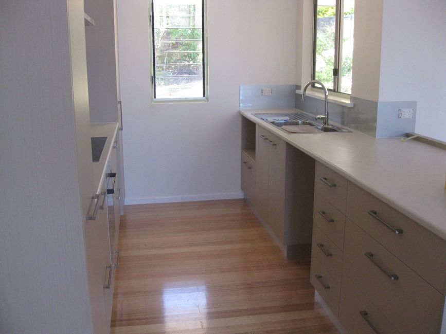 An Empty Kitchen With A Sink And A Window — Sven Margraf Constructions Pty Ltd In Atherton QLD