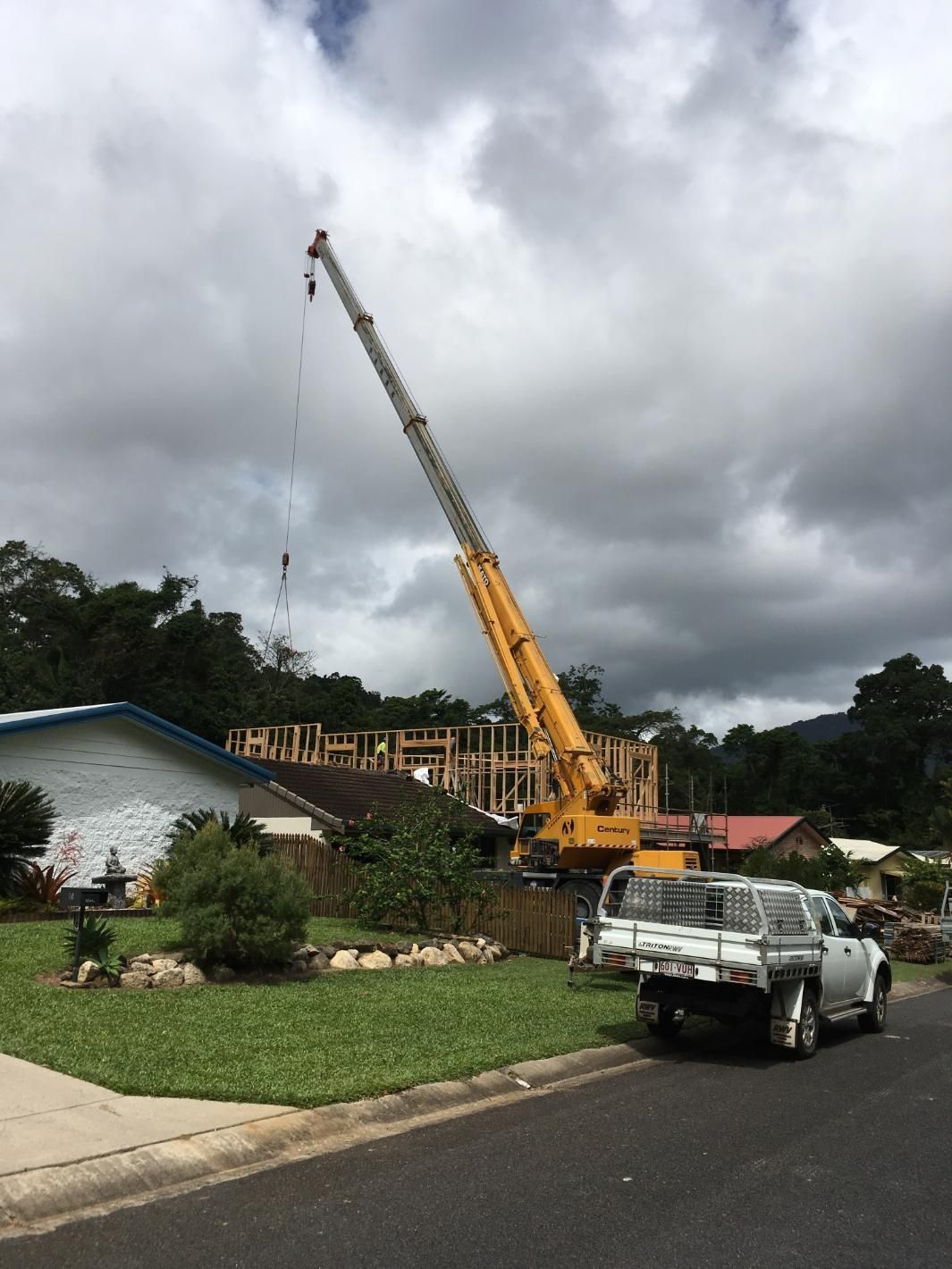 A Yellow Crane In Front Of A House Under Construction — Sven Margraf Constructions Pty Ltd In Atherton QLD