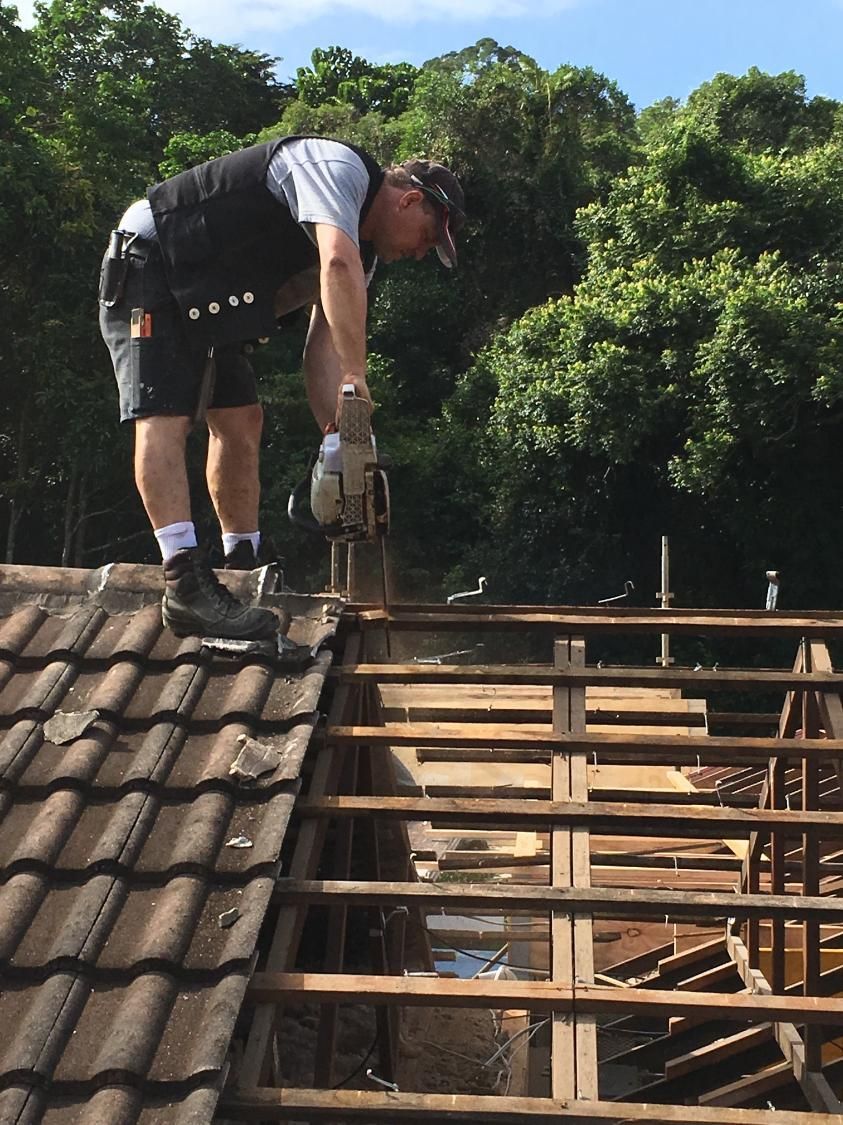 A Man Is Working On The Roof Of A Building — Sven Margraf Constructions Pty Ltd In Atherton QLD