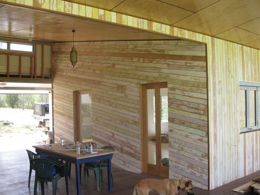 A Dog Standing In Front Of A Wooden Wall With A Table And Chairs — Sven Margraf Constructions Pty Ltd In Atherton QLD