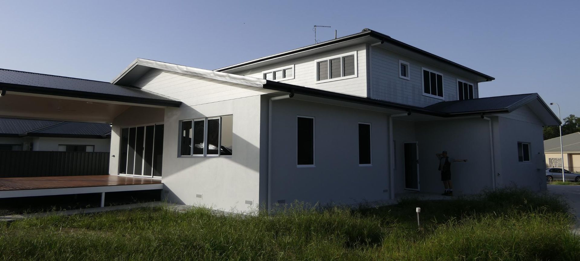 A Large White House With A Lot Of Windows Is Surrounded By Tall Grass — Sven Margraf Constructions Pty Ltd In Atherton QLD