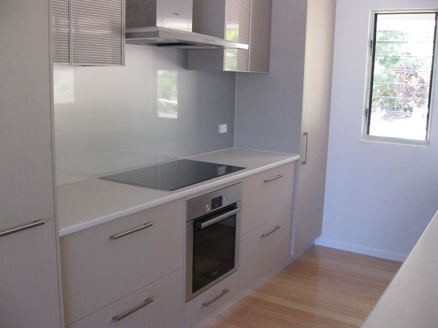 A Kitchen With Stainless Steel Appliances And White Cabinets — Sven Margraf Constructions Pty Ltd In Atherton QLD