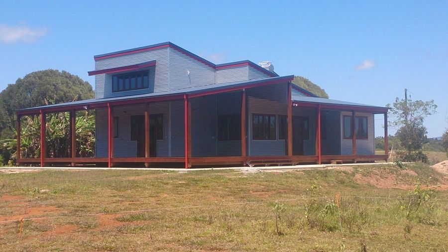 A Large House Is Sitting In The Middle Of A Grassy Field — Sven Margraf Constructions Pty Ltd In Atherton QLD