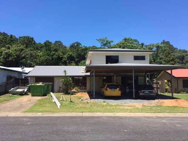 A Yellow Car Is Parked Under A Canopy In Front Of A House — Sven Margraf Constructions Pty Ltd In Atherton QLD