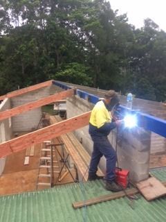 A Man Is Welding On The Roof Of A Building — Sven Margraf Constructions Pty Ltd In Atherton QLD