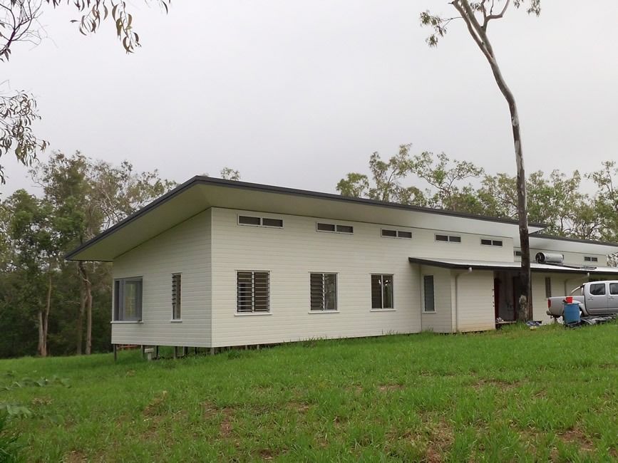 A Large White House Sits In The Middle Of A Grassy Field — Sven Margraf Constructions Pty Ltd In Atherton QLD