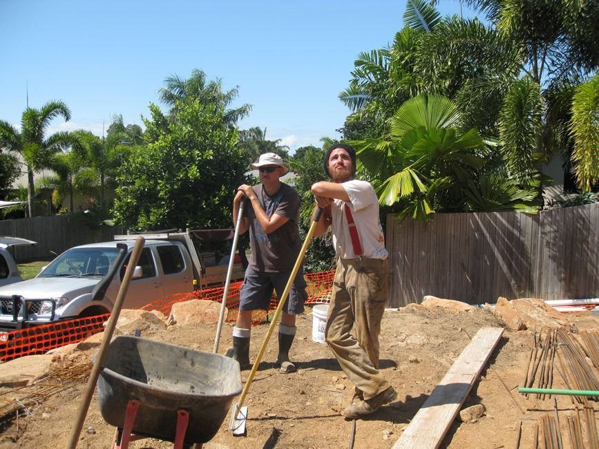 Two Men Are Working On A Construction Site With A Wheelbarrow — Sven Margraf Constructions Pty Ltd In Atherton QLD