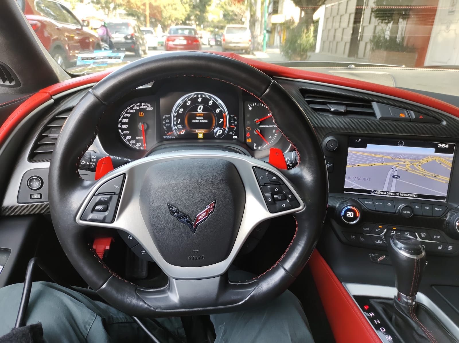 Una persona está sentada en el asiento del conductor de un corvette.
