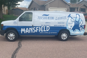 A mansfield van is parked in front of a house