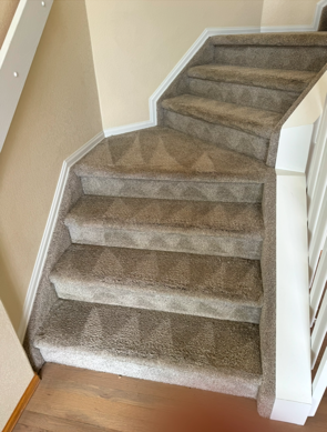 A staircase with a carpeted staircase and a white railing.