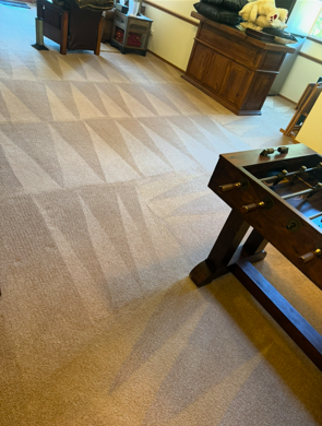 A living room with a foosball table and chairs