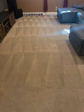 A living room with a couch and chairs and a carpeted floor.