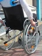 Person in a wheelchair going up an access ramp