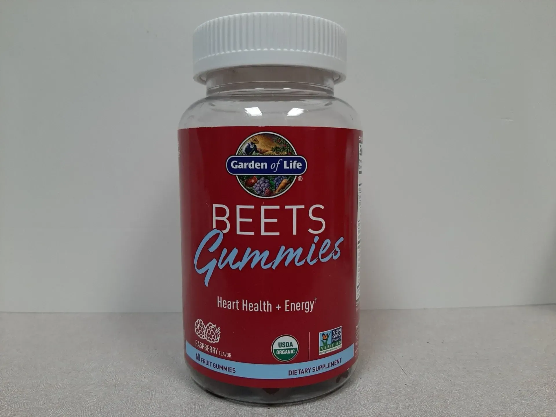 A bottle of Garden of Life Beets Gummies on a white surface, featuring red branding, organic, and non-GMO labels.