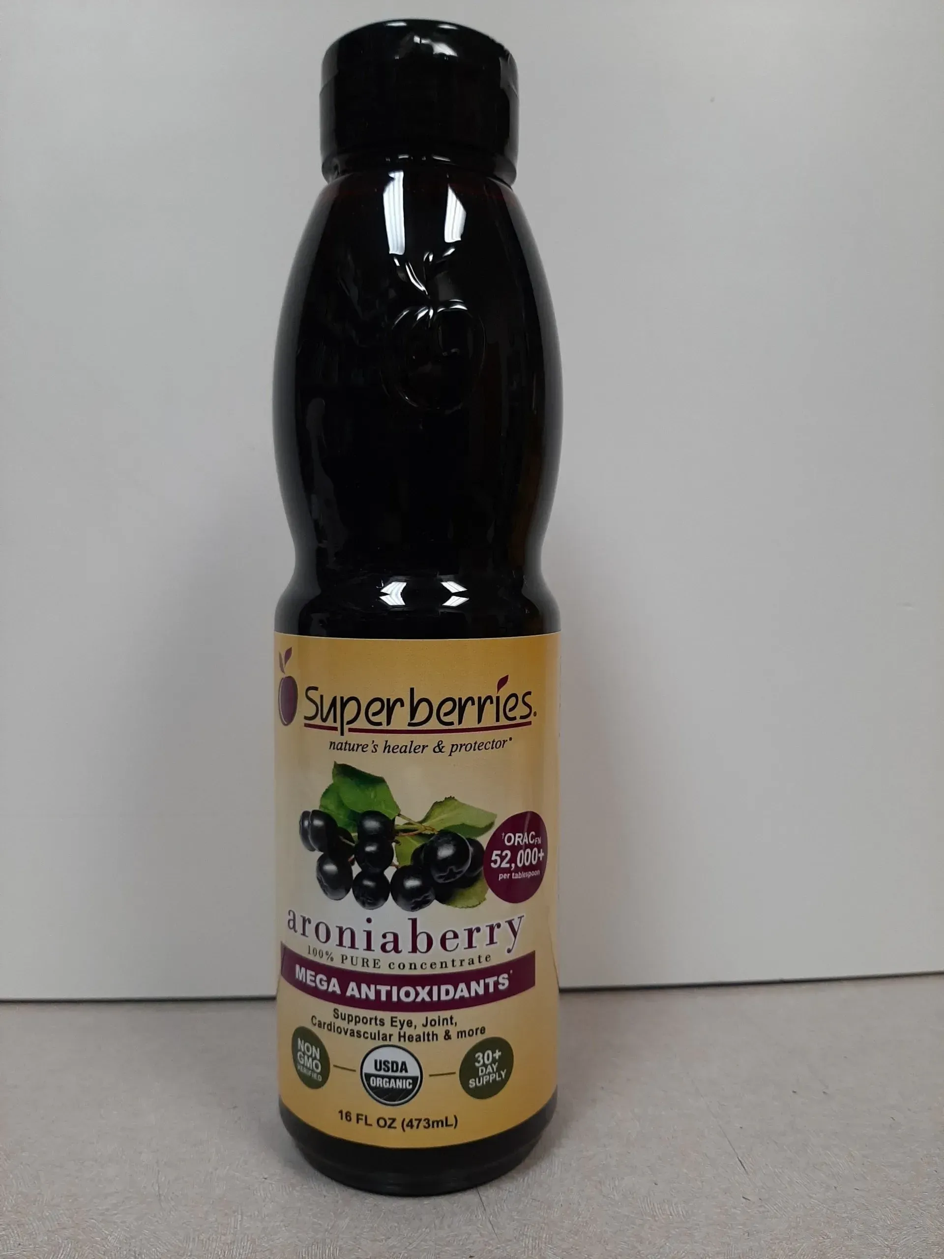 A bottle of Superberries aronia berry juice concentrate against a plain background.