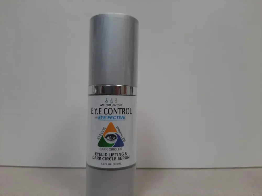 A cylindrical silver bottle of Eye Control Eyelid Lift and Dark Circle Serum against a plain, light background.