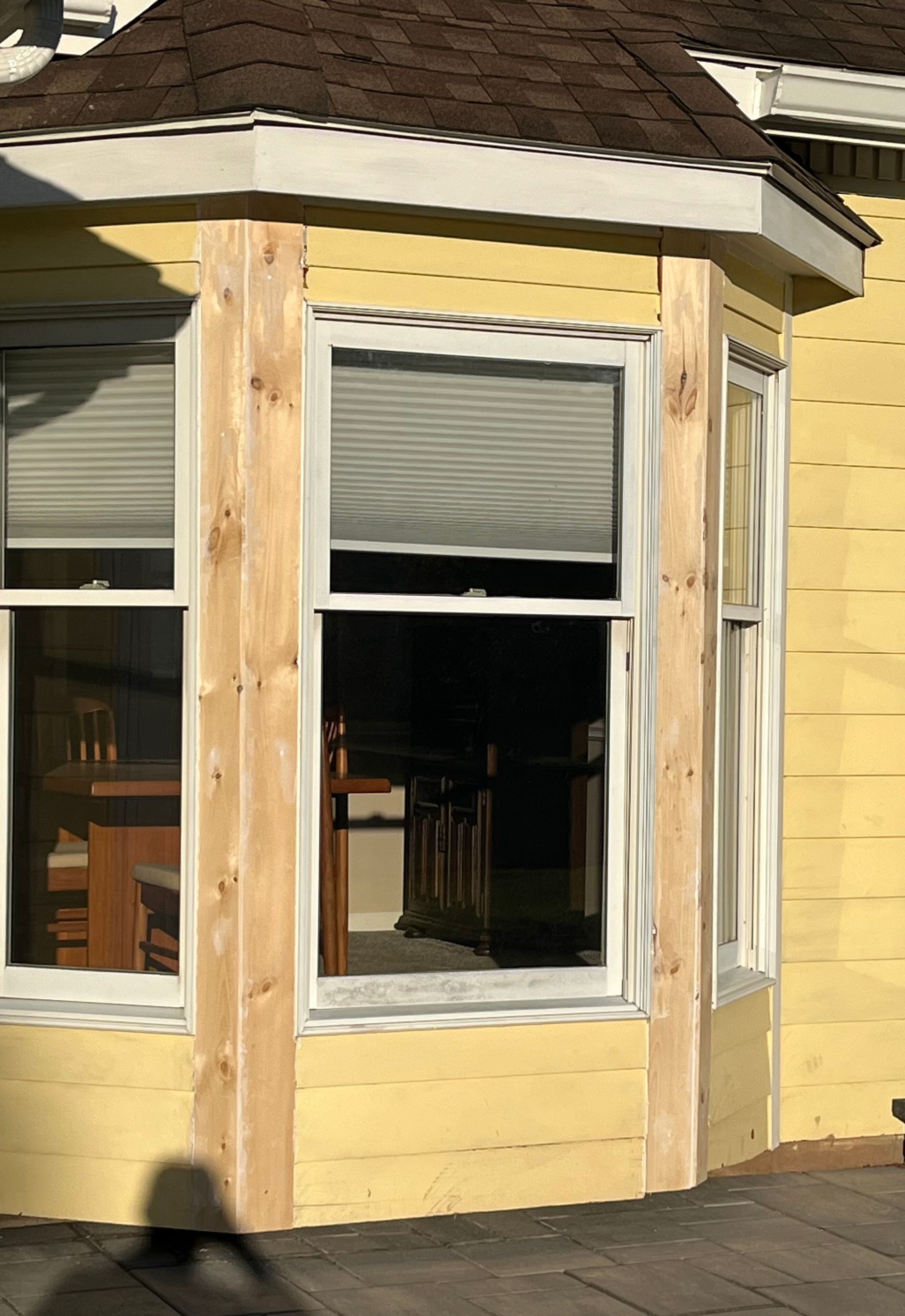 The outside of a yellow house before the beginning of a gutter installation.