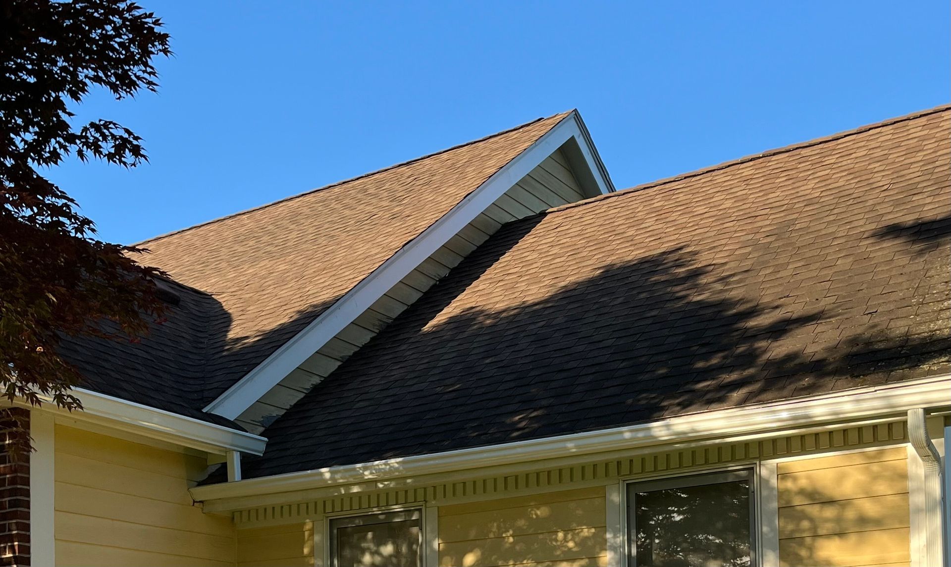 A multi-tier gutter installation complete on a yellow house