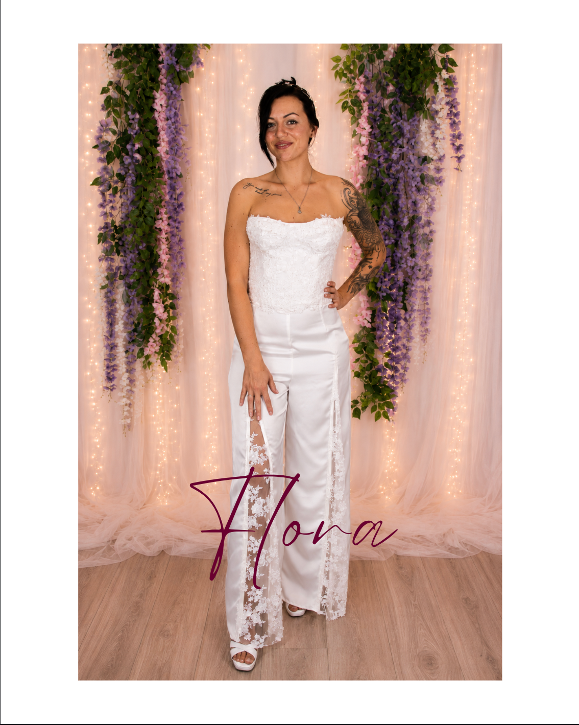 Woman in white strapless dress posing before floral drapes with the word “Flora” overlaid.
