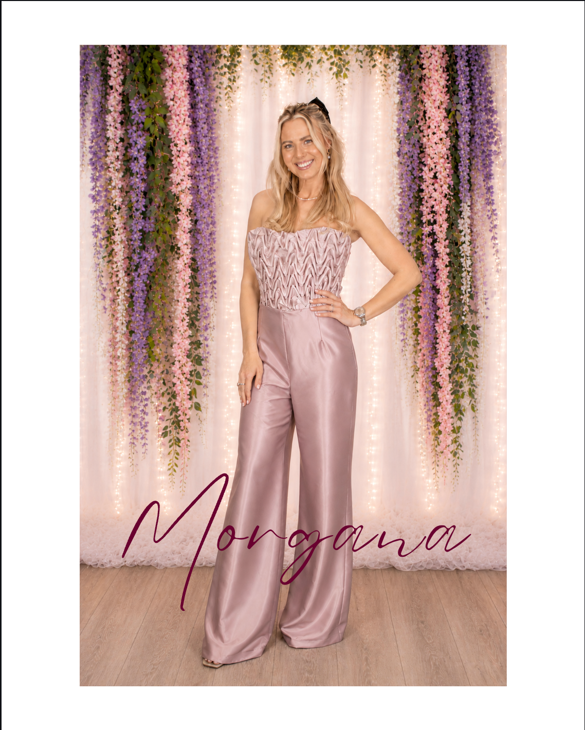 Woman posing in a pink satin outfit before a floral backdrop with the name “Morgana” written below