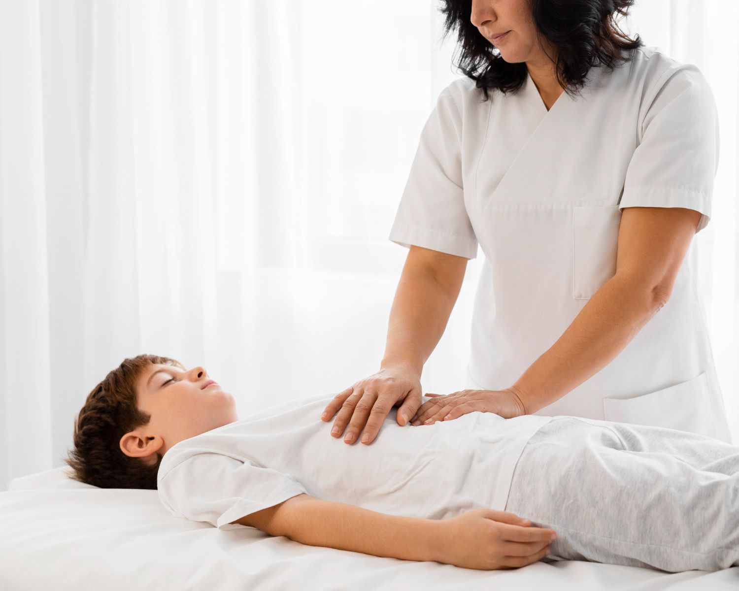 A woman is giving a child a massage on a bed.