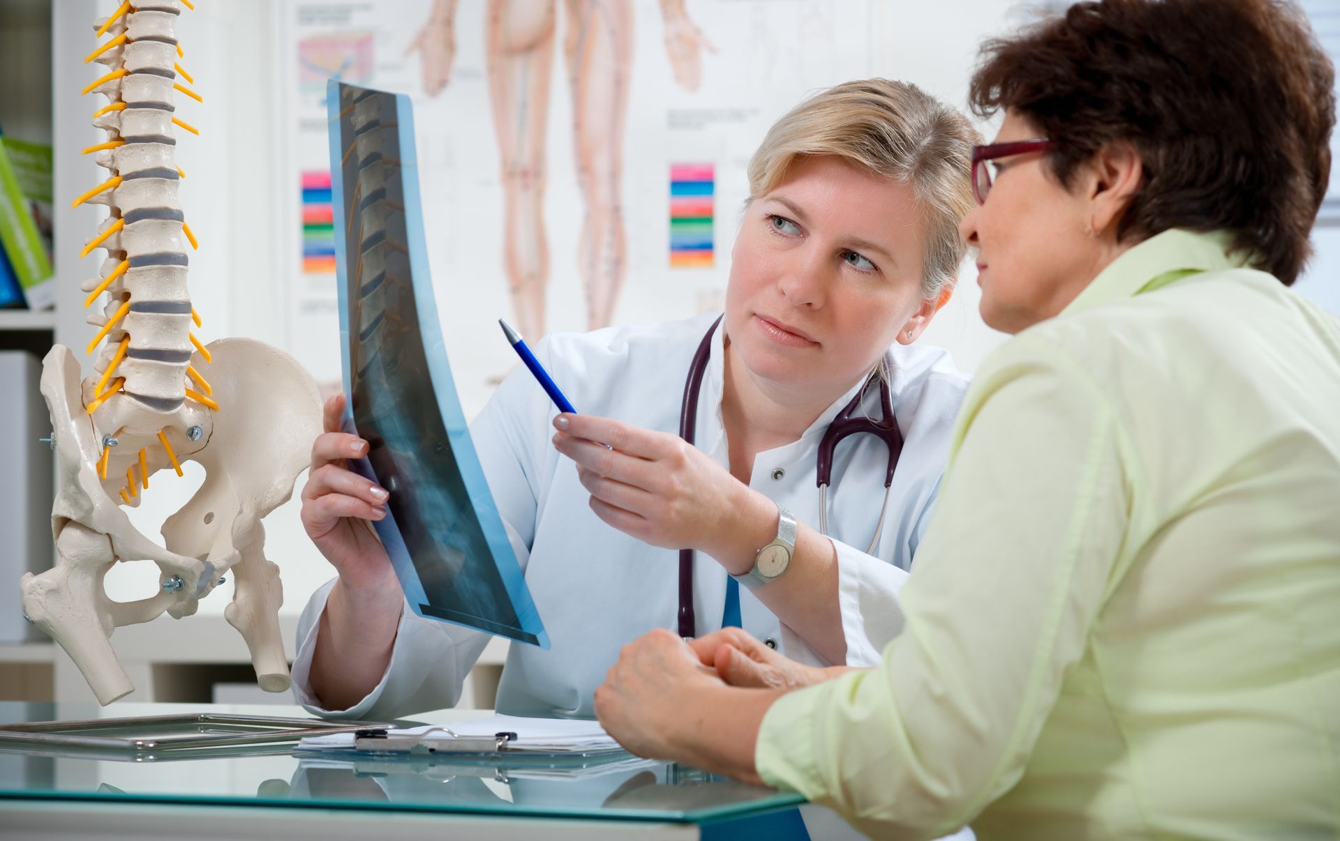 A doctor is looking at an x-ray with a patient.