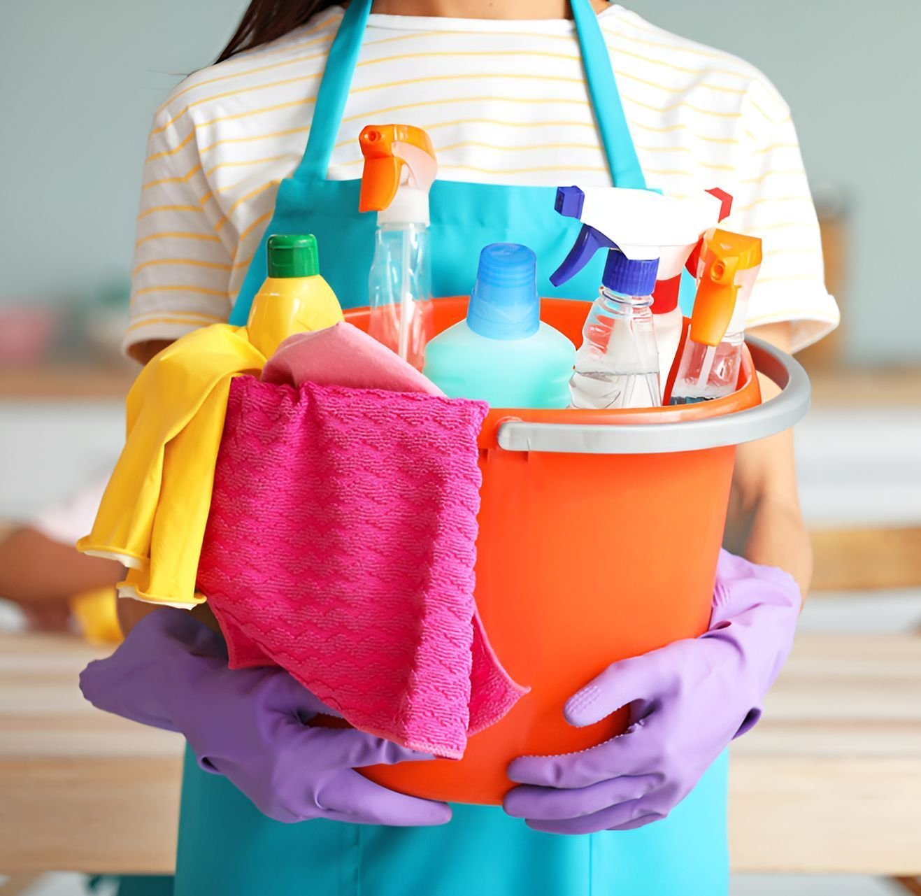 A Woman Is Holding A Bucket Full Of Cleaning Supplies — Sunchem Quality Cleaning Products In Gympie, QLD