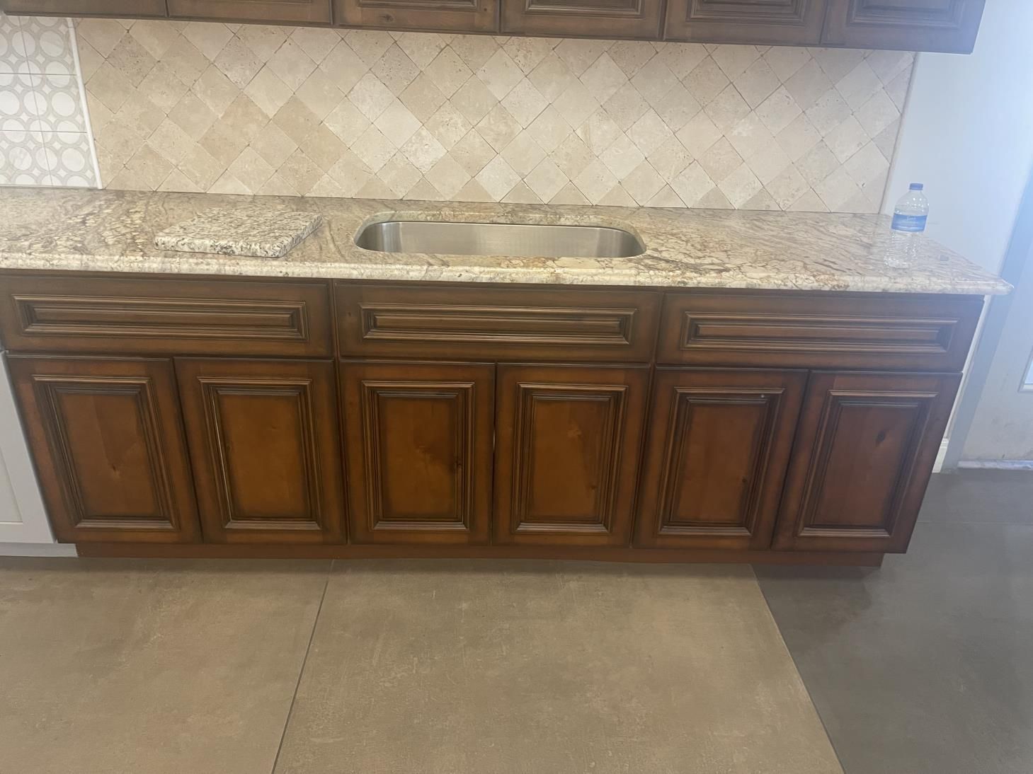 a kitchen under construction with blue tape on the floor .
