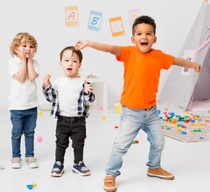 Tres niños en una sala de juegos. Uno sorprendido, otro comiendo y el tercero bailando con entusiasmo.